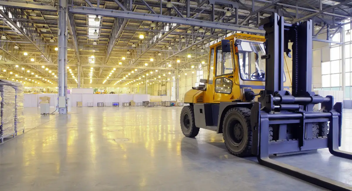 Forklift moving containers in factory